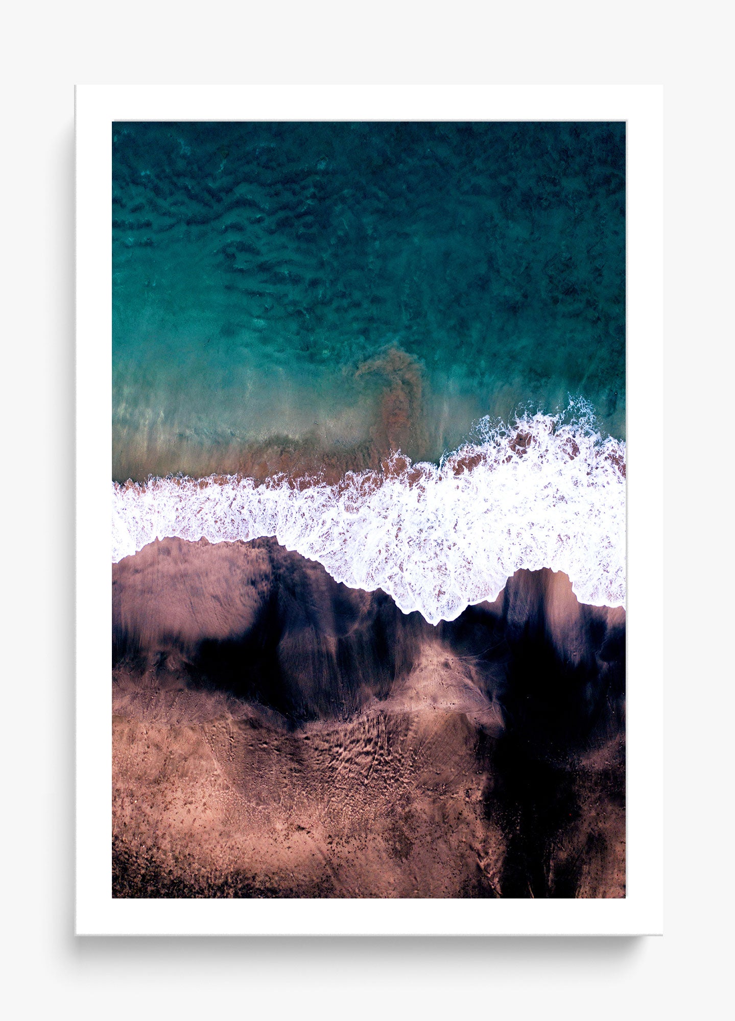 Black & blue wall decor featuring an aerial view of ocean waves meeting a sandy shore.