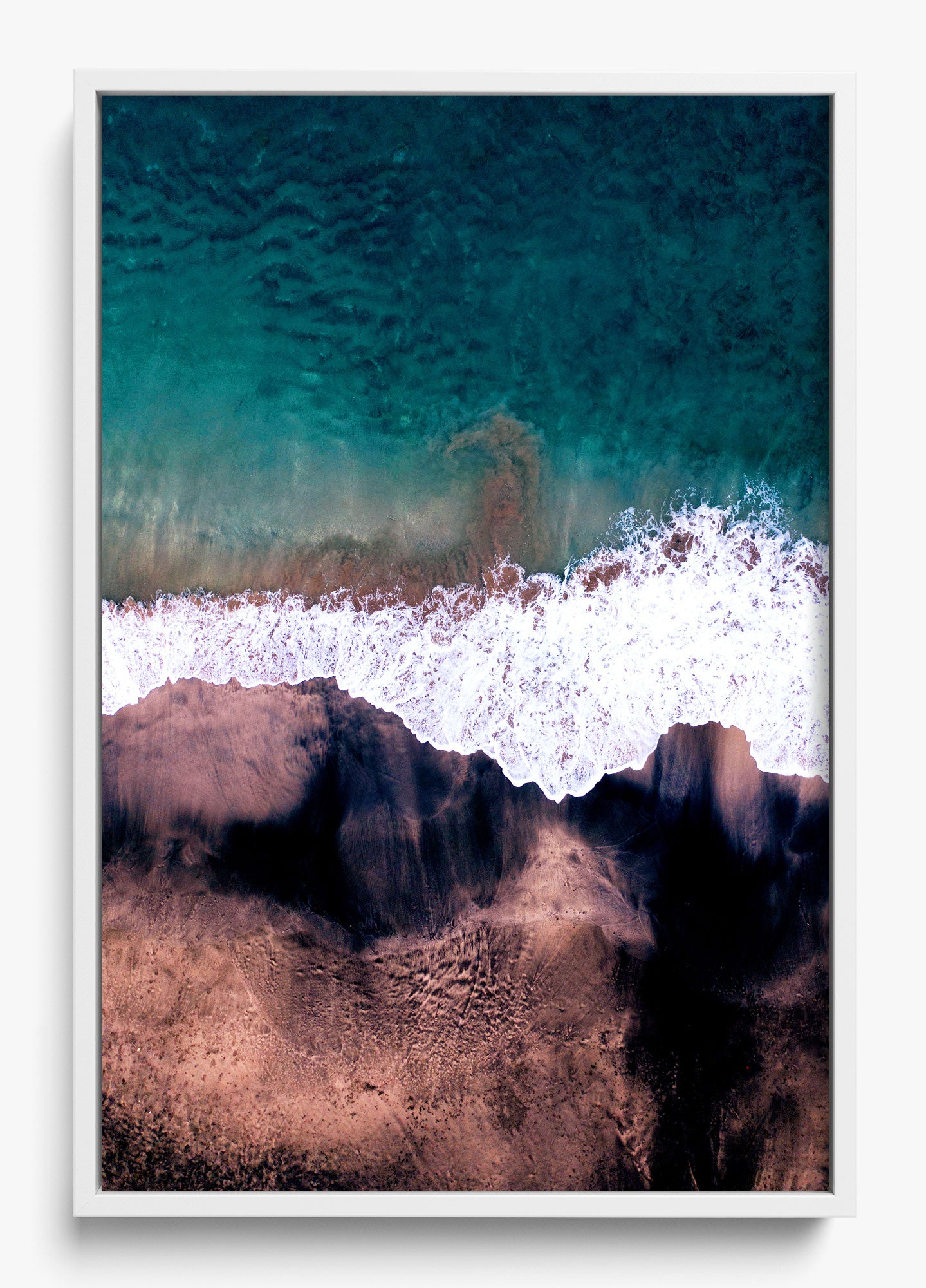 Black and blue wall decor featuring an aerial view of a beach with waves crashing on a sandy shore.